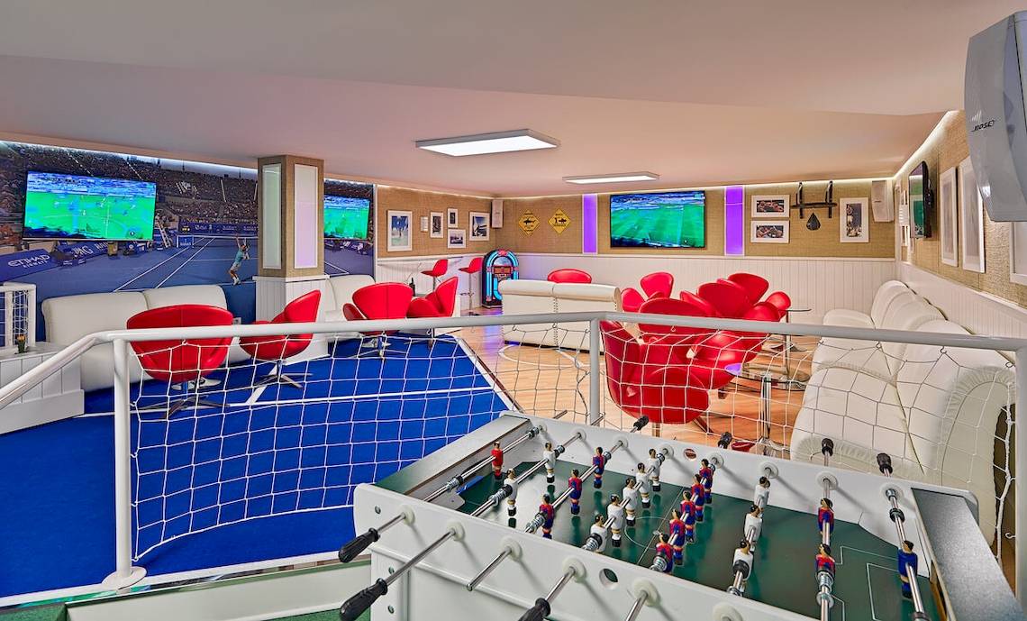 Spielzimmer im H10 Conquistador Hotel mit Tischfußball, roten Stühlen und Fernsehern