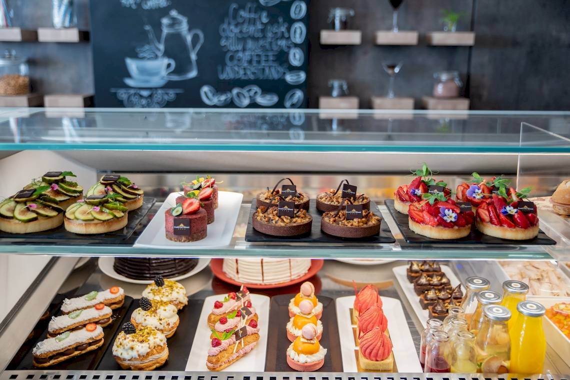 Pâtisserie-Display im Ramla Bay Resort mit verschiedenen Desserts und Konditoreiwaren.