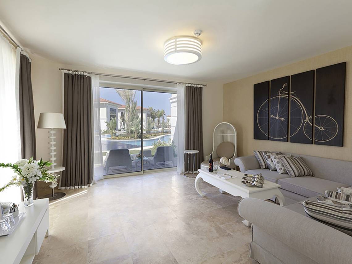 Wohnzimmer im Paloma Oceana Hotel mit Blick auf den Pool und Außenbereich.