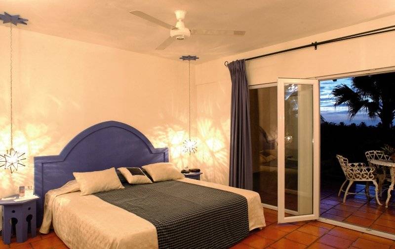 Schlafzimmer im Jardin del Eden Boutique Hotel mit offenem Balkon und Aussicht.