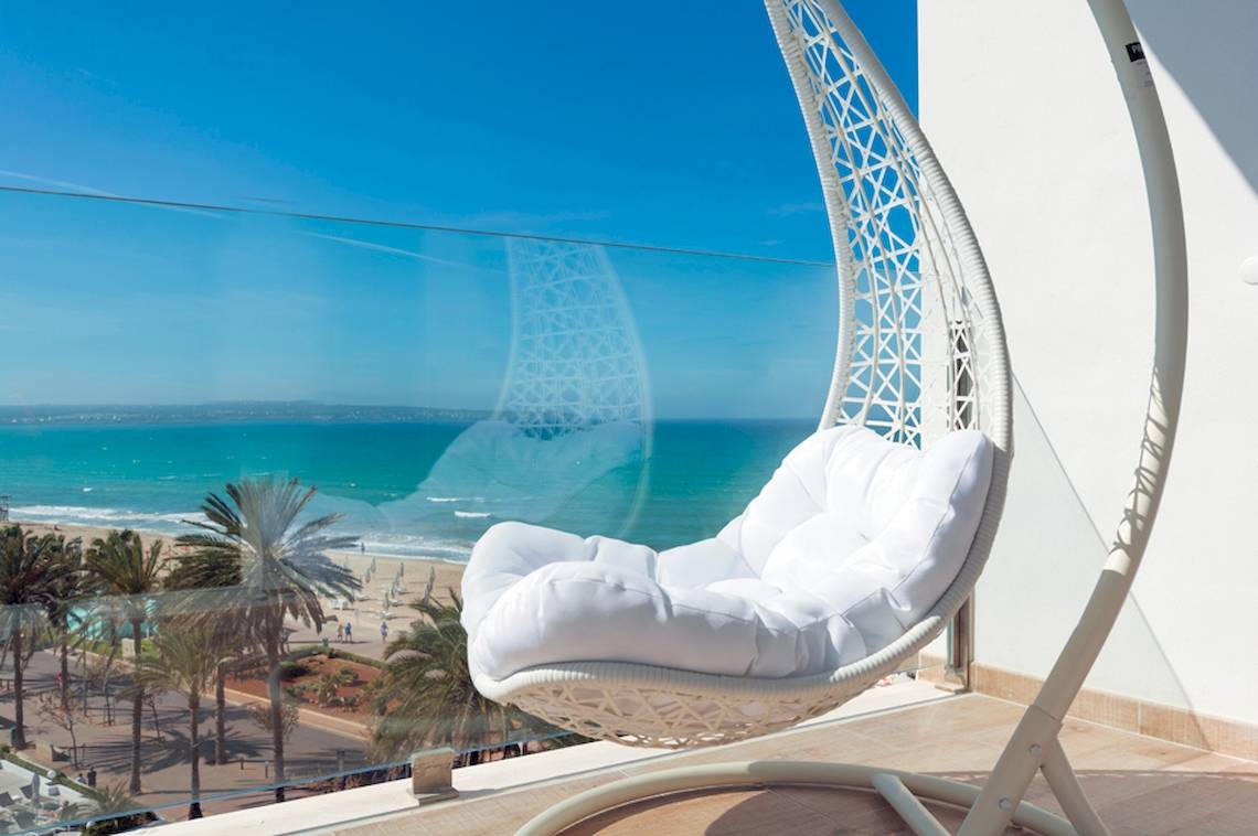 Ein Hängesessel auf dem Balkon des HSM Golden Playa Hotels mit Blick auf das Meer.