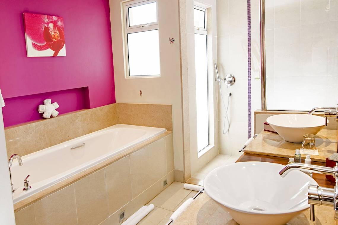 Badezimmer im Tamassa Bel Ombre Hotel mit Badewanne und Waschbecken.