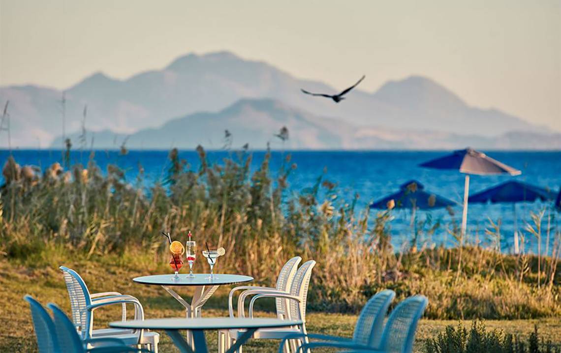 Außenterrasse des Porto Bello Royal Hotels mit Blick auf das Meer und eine Vogel in Flug