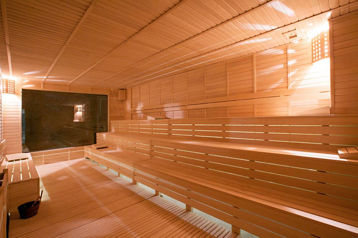 Innenansicht der Sauna im Diamond Elite Hotel & Spa mit Holzbänken und hellem Licht.