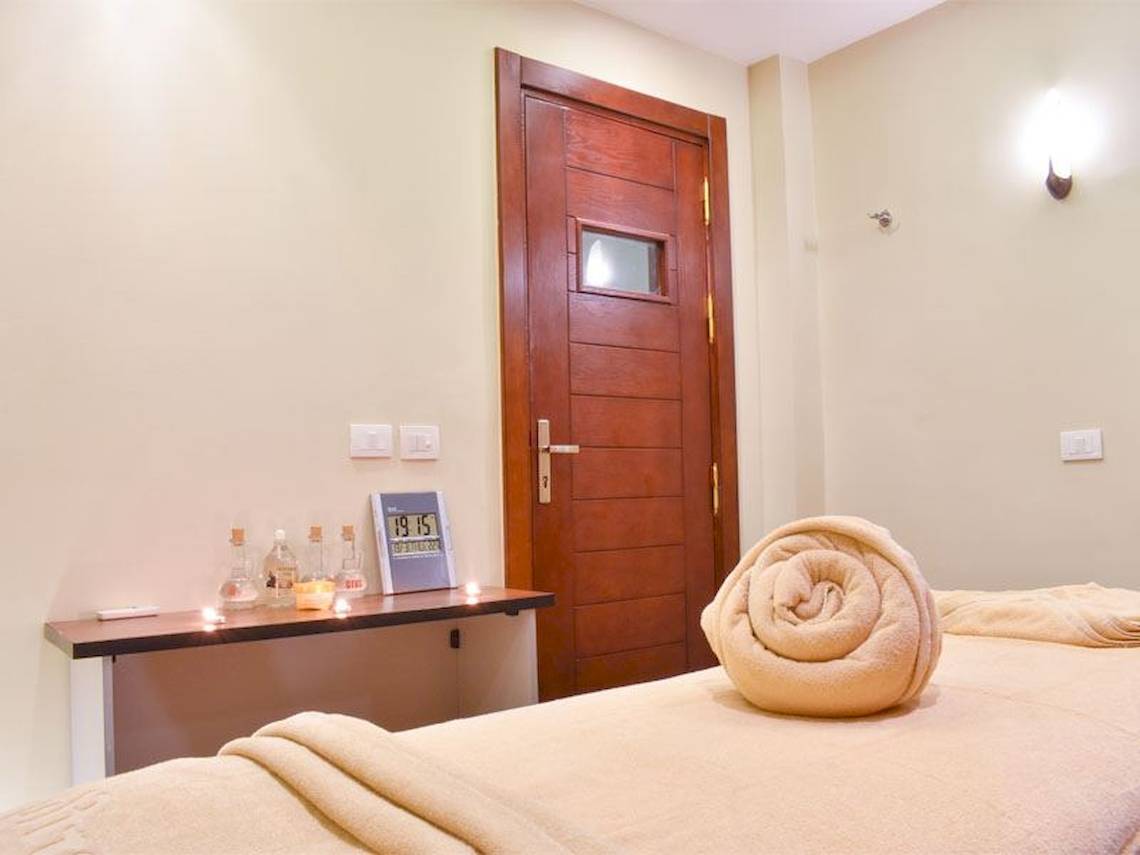 Massage Zimmer im Parrotel Beach Resort mit vorbereitetem Bett und Kerzenlicht.