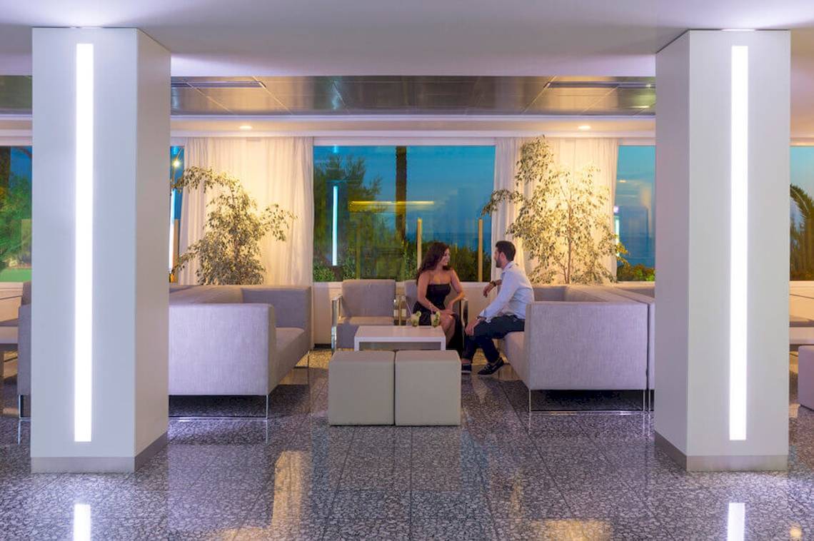 Lobby-Lounge-Bereich des HSM Golden Playa Hotels mit Paar auf Sofas.