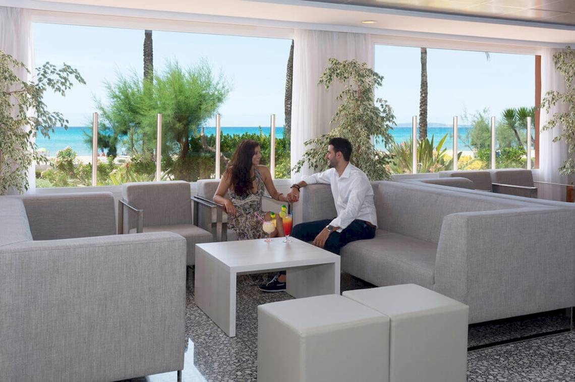 Paar im HSM Golden Playa Hotel Lounge Bereich mit Meerblick und weißen Möbeln.