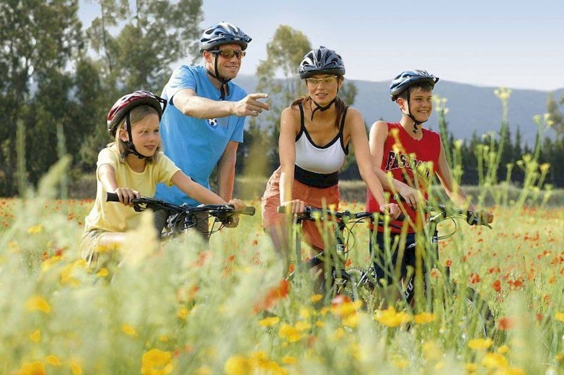 Familie macht Fahrradtour durch ein Blumenfeld im Falkensteiner Club Funimation Garden Calabria