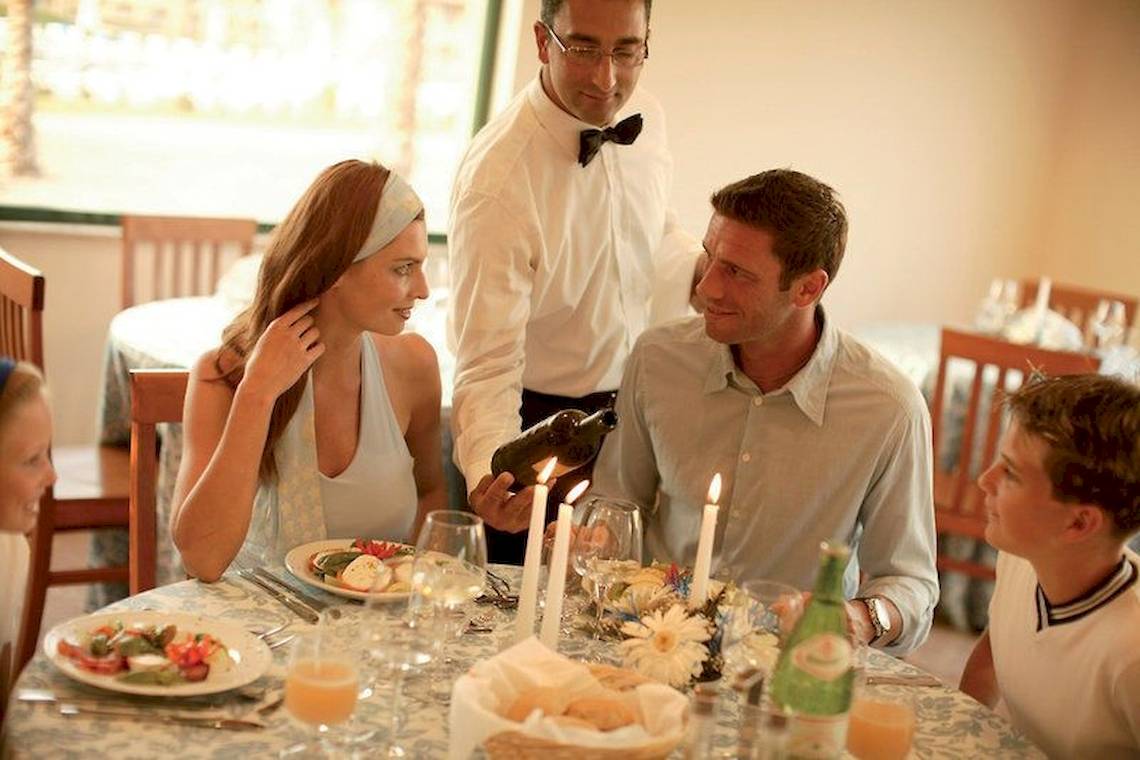 Familie genießt Essen am Tisch im Falkensteiner Club Funimation Garden Calabria