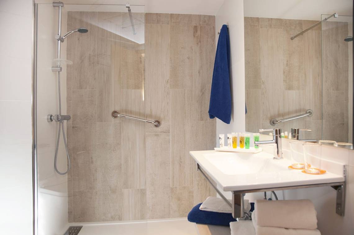 Badezimmer des HSM Golden Playa Hotels mit blauem Handtuch und moderner Einrichtung.