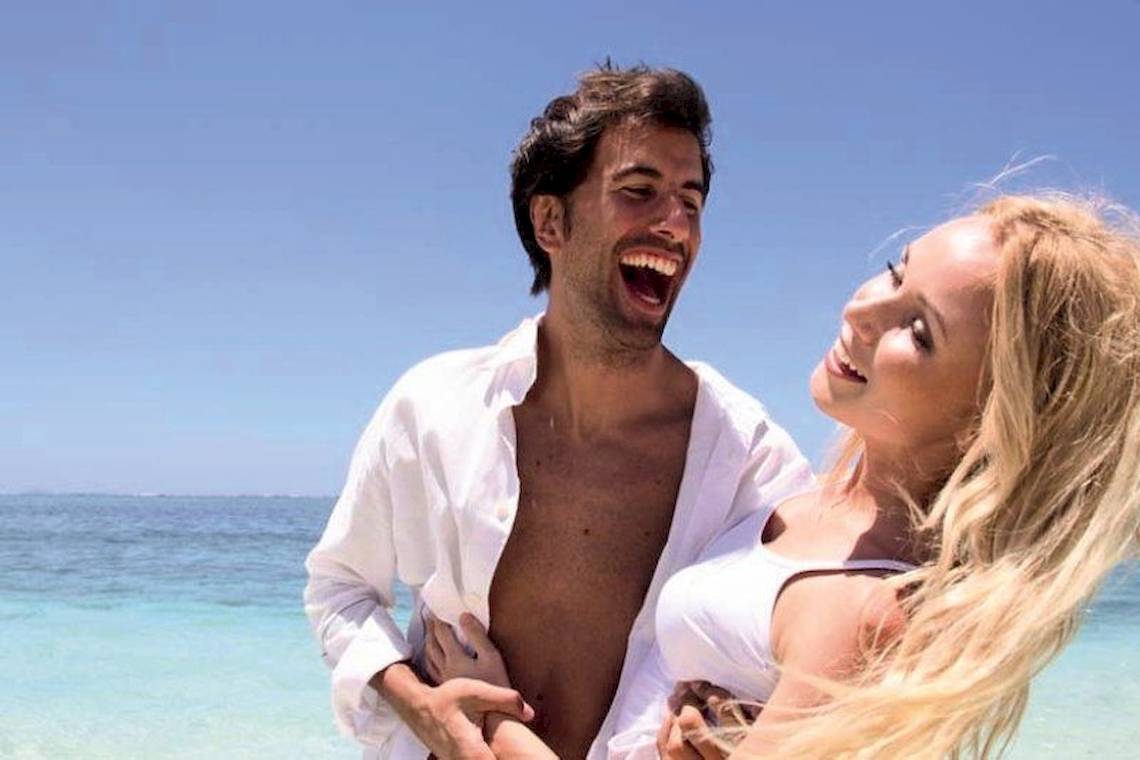 Ein Mann und eine Frau grinsen auf dem Sandstrand im SALT of Palmar.