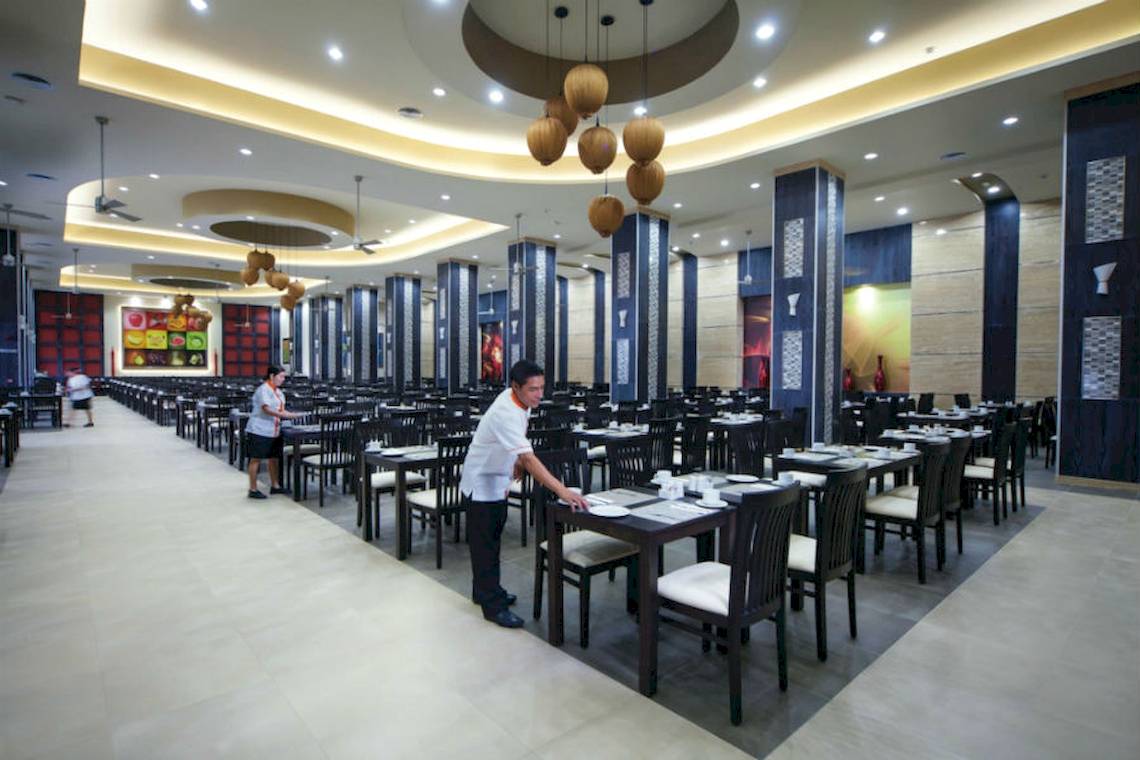 Innenansicht des Restaurants im Riu Cancun Hotel mit eingerichteten Tischen und Stühlen.