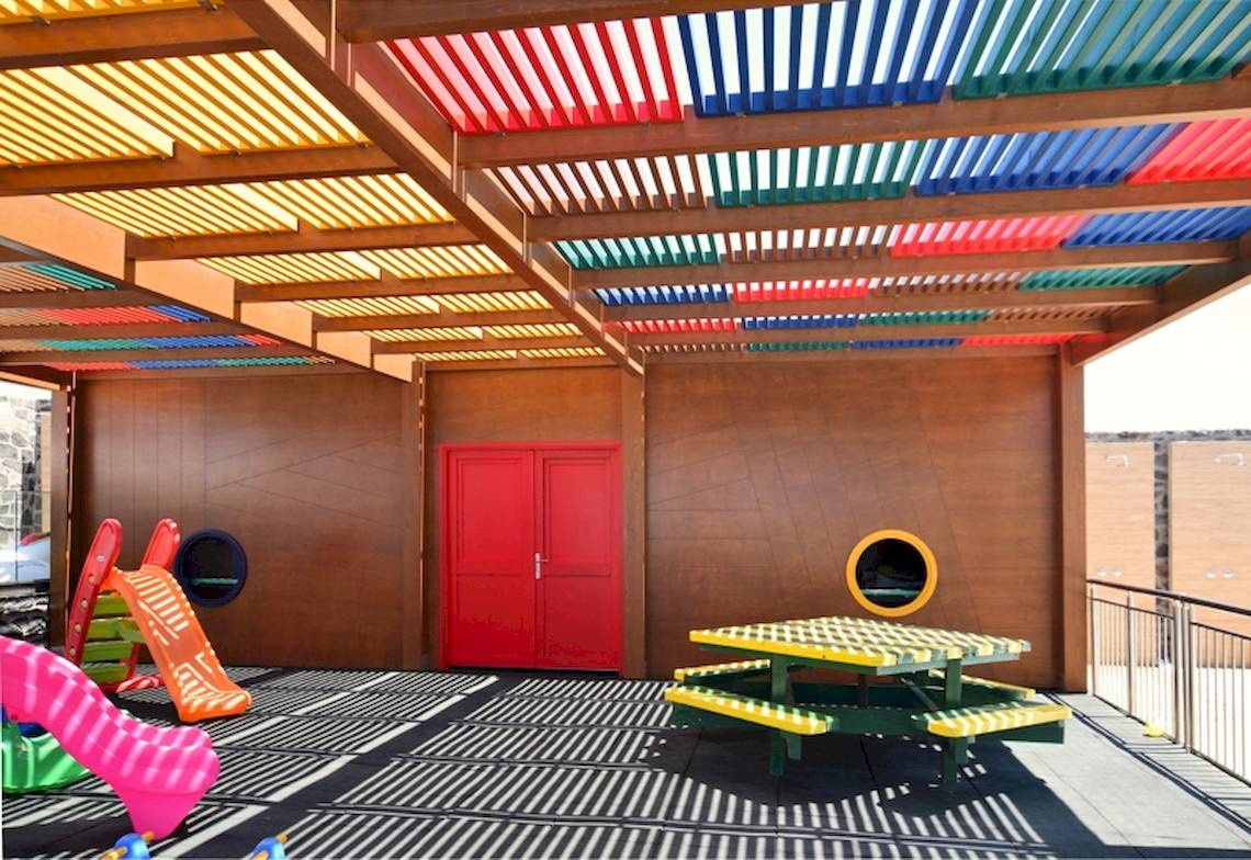 Kinderspielplatz im Astir Beach Hotel auf Kreta unter einer bunten Pergola.