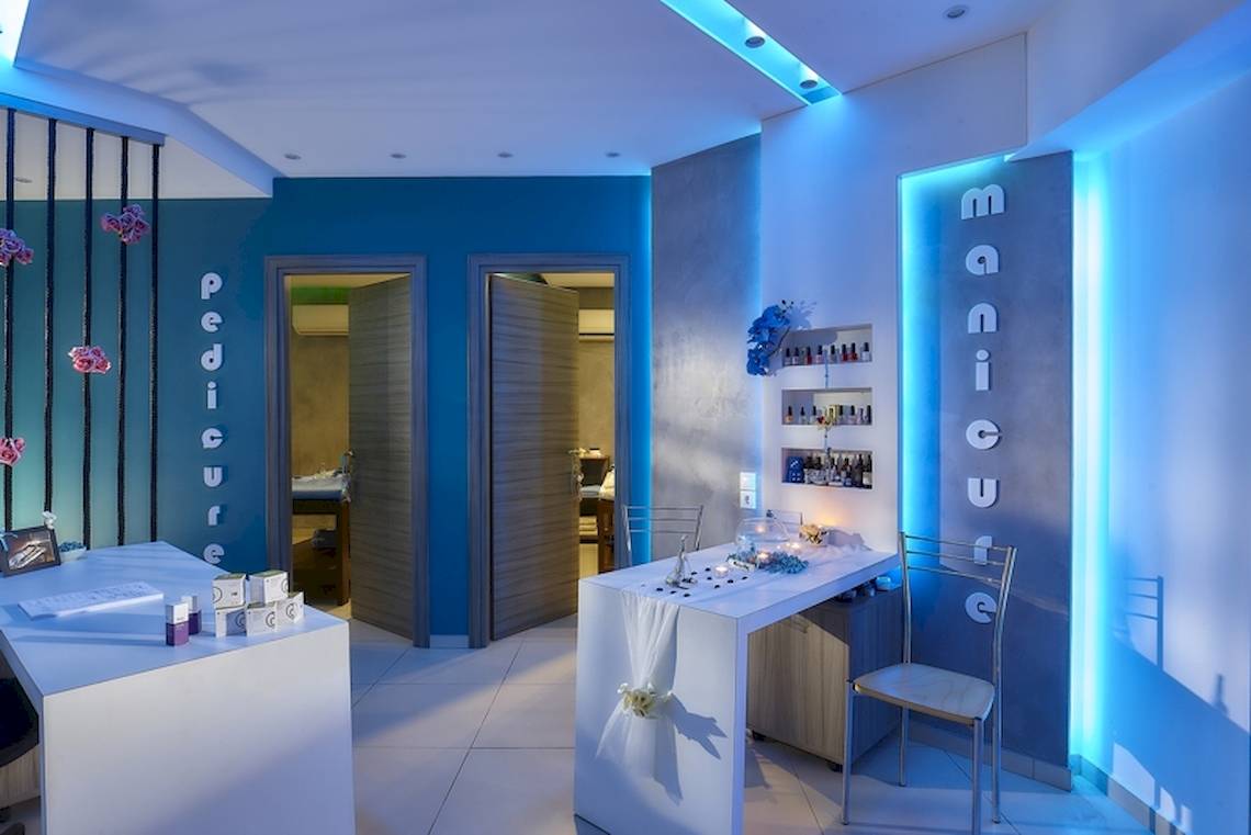 Innenansicht des Pediküre-Salons im Astir Beach Hotel auf Kreta mit blauen Wänden und Beleuchtung.