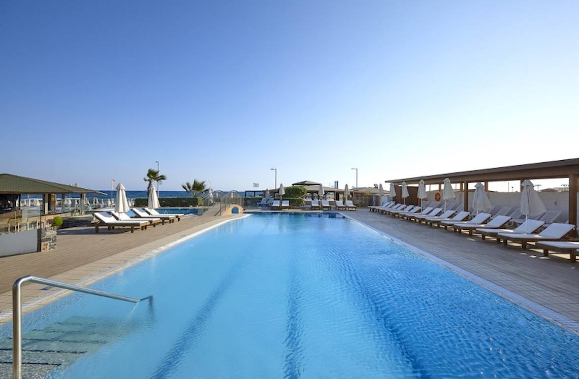 Außenpool des Astir Beach Hotels auf Kreta mit Sonnenliegen und Sonnenschirmen.