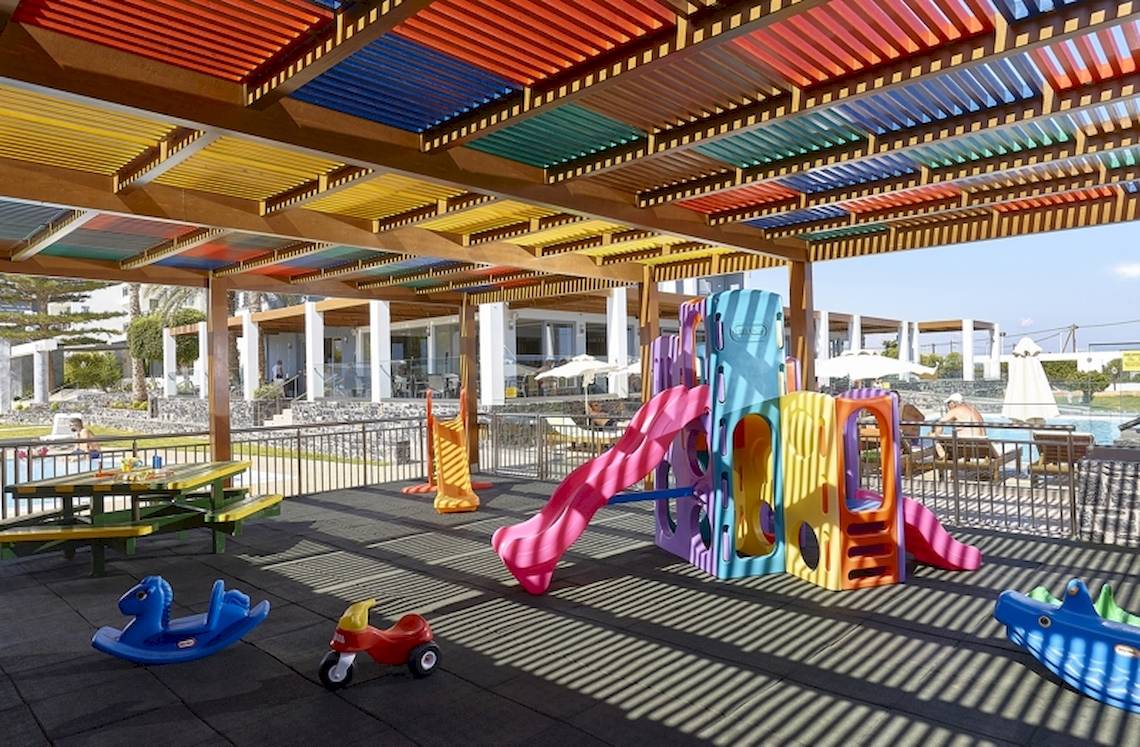 Kinderspielplatz im Astir Beach Hotel in Kreta, geschützt unter einer bunten Pergola.