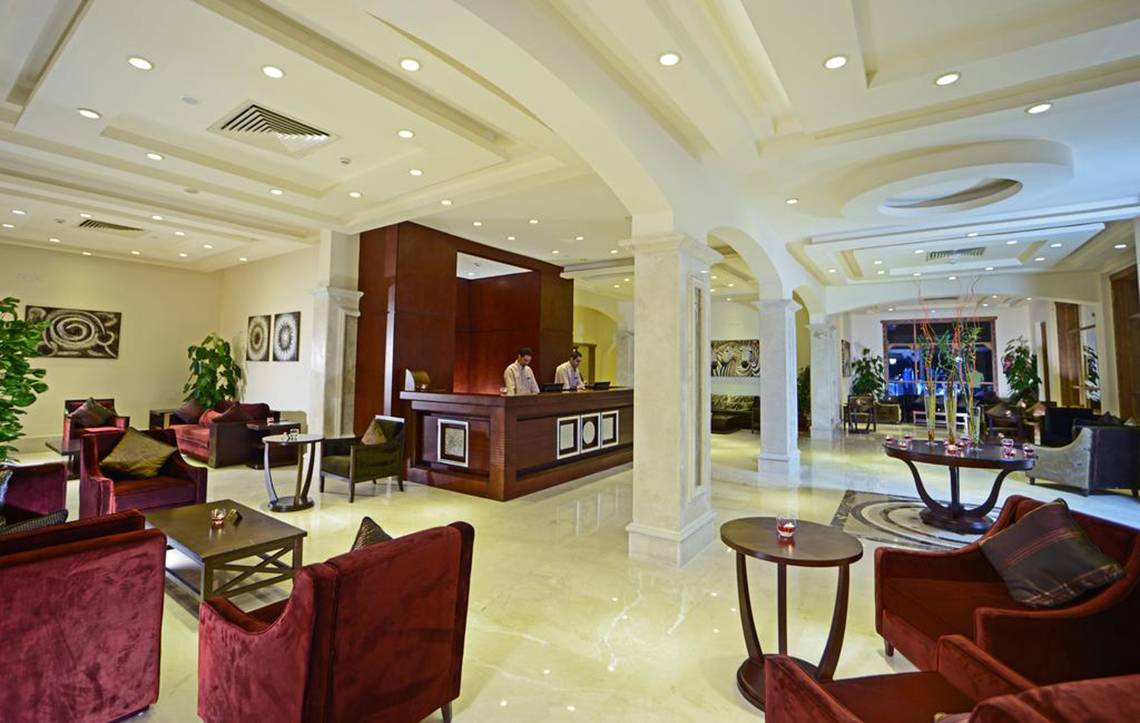Empfangsbereich des Charmillion Club Aqua Park Hotels mit Rezeption, Sofas und Tischen.