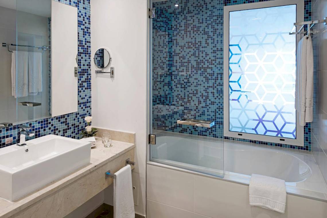 Badezimmer im Iberostar Origin Bella Vista Varadero Hotel mit blauen Fliesen und einer Badewanne.