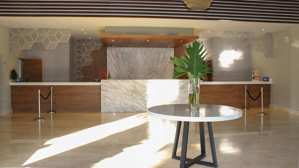 Lobby des Casa Marina Beach Resort mit Tisch, Pflanze und Empfangstresen.