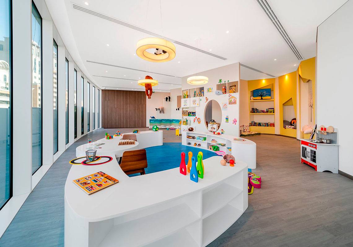 Kinderbereich im FIVE Jumeirah Village Hotel mit hellen Farben, Spielzeug und Bücherregalen.