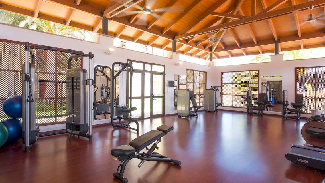 Fitnesscenter im Iberostar Selection Anthelia Hotel mit verschiedenen Trainingsgeräten und blauen Medizinbällen.
