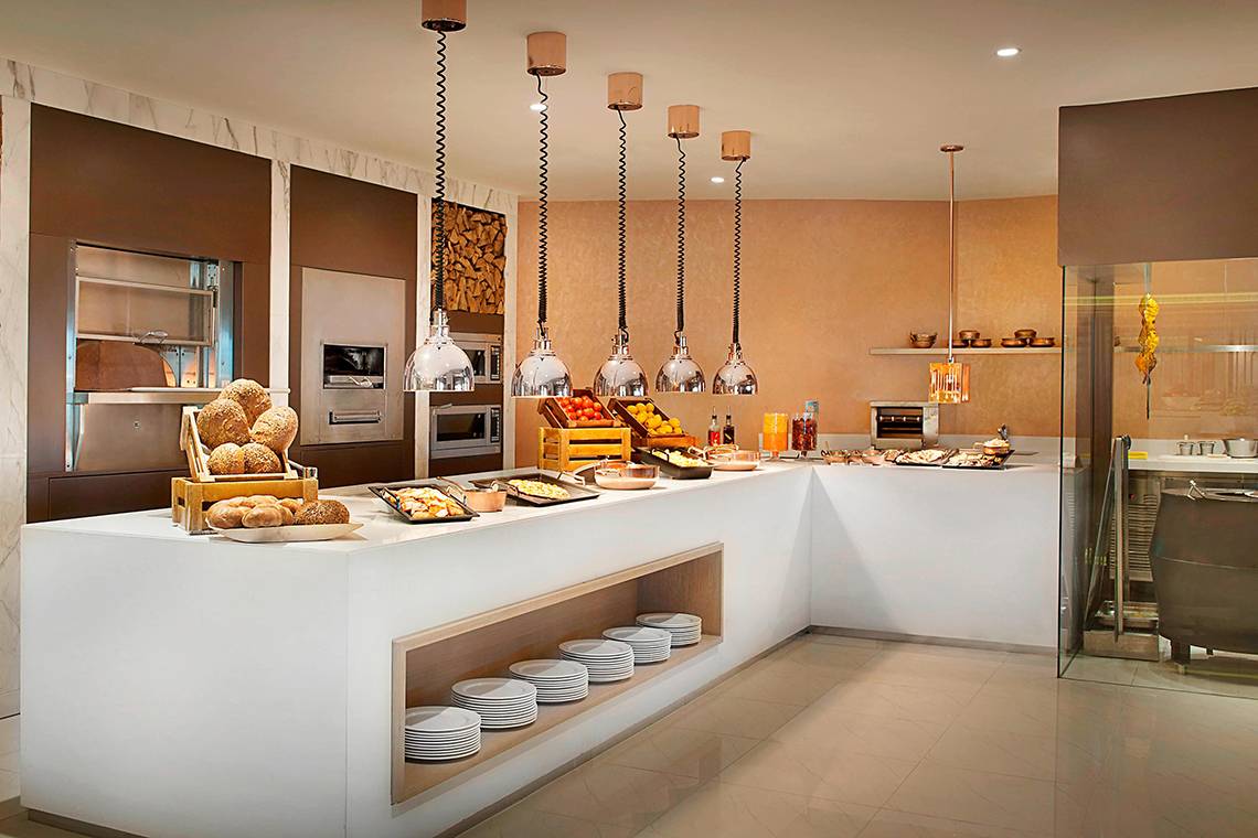 Buffettisch im Habtoor Grand Resort & Spa mit verschiedenen Gerichten und Utensilien.