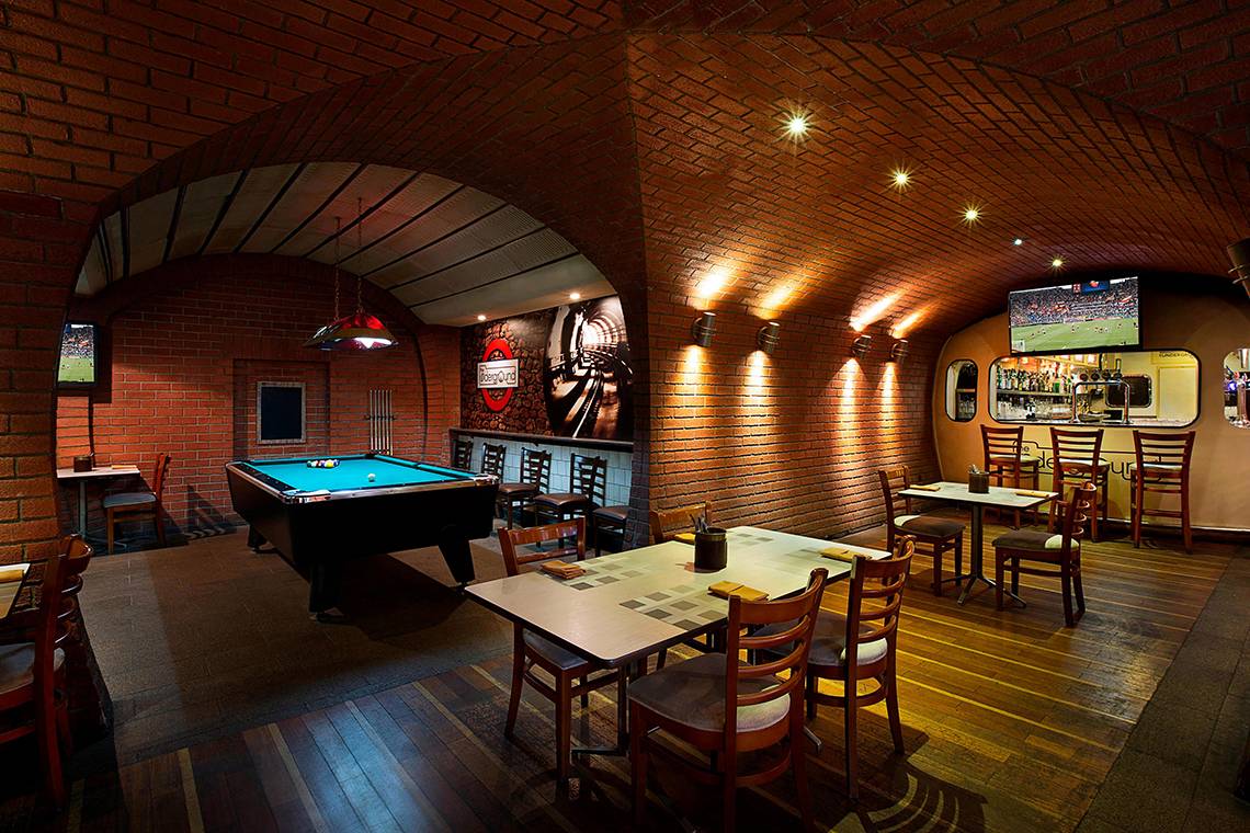 Innenansicht der Pool-Lounge im Habtoor Grand Resort & Spa mit Billardtisch und Fernseher.
