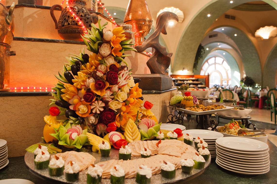 Ein Buffettisch im Grand Resort Hurghada mit einer Kunstblume aus Obst und Gemüse.