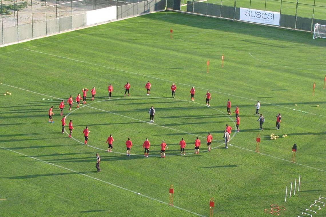 Spieler des Susesi Luxury Resort stehen im Kreis auf einem Fußballfeld.