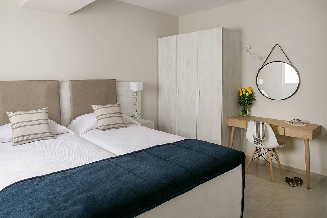 Doppelbett-Zimmer im Louis Paphos Breeze Hotel mit weißem Bett, Kopfkissen und Decke.