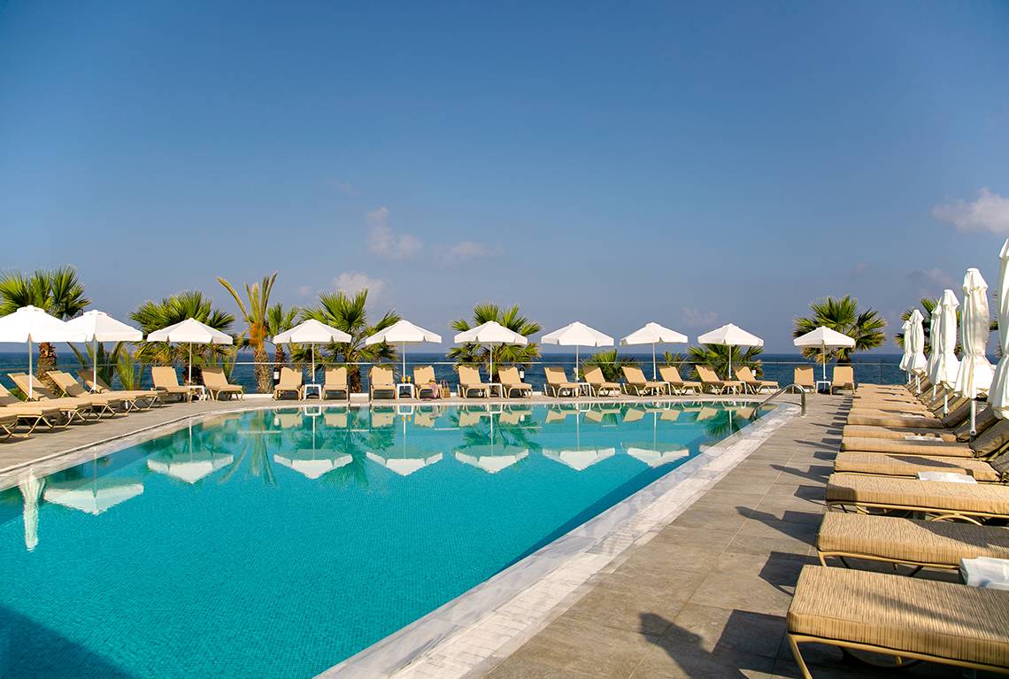 Der Außenpool des Louis Paphos Breeze Hotels mit Sonnenliegen und Sonnenschirmen