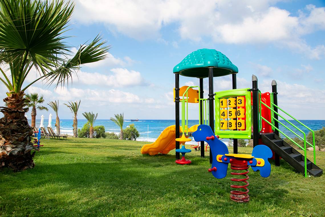 Spielplatz am Strand des Louis Paphos Breeze Hotels mit Blick auf das Meer.