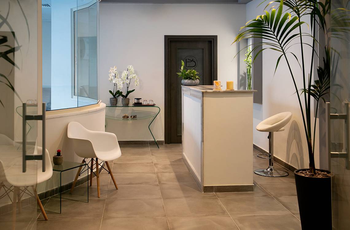 Lobby des Louis Paphos Breeze Hotels mit moderner Einrichtung und Pflanzen.