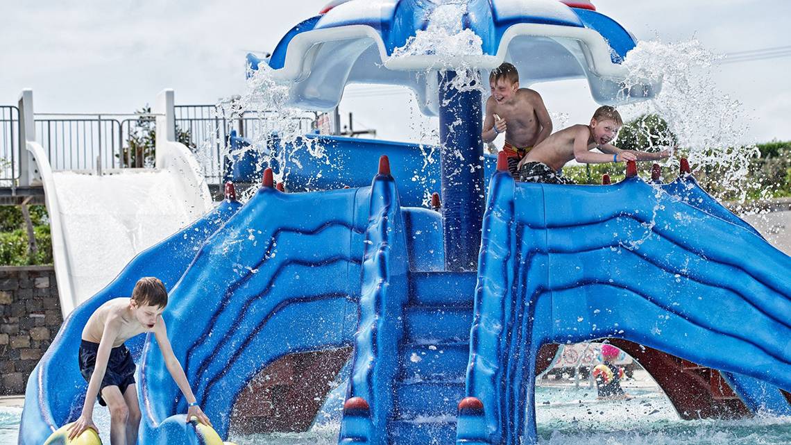 Drei Kinder spielen auf einer blauen Wasserrutsche im Rodos Princess Beach Hotel.