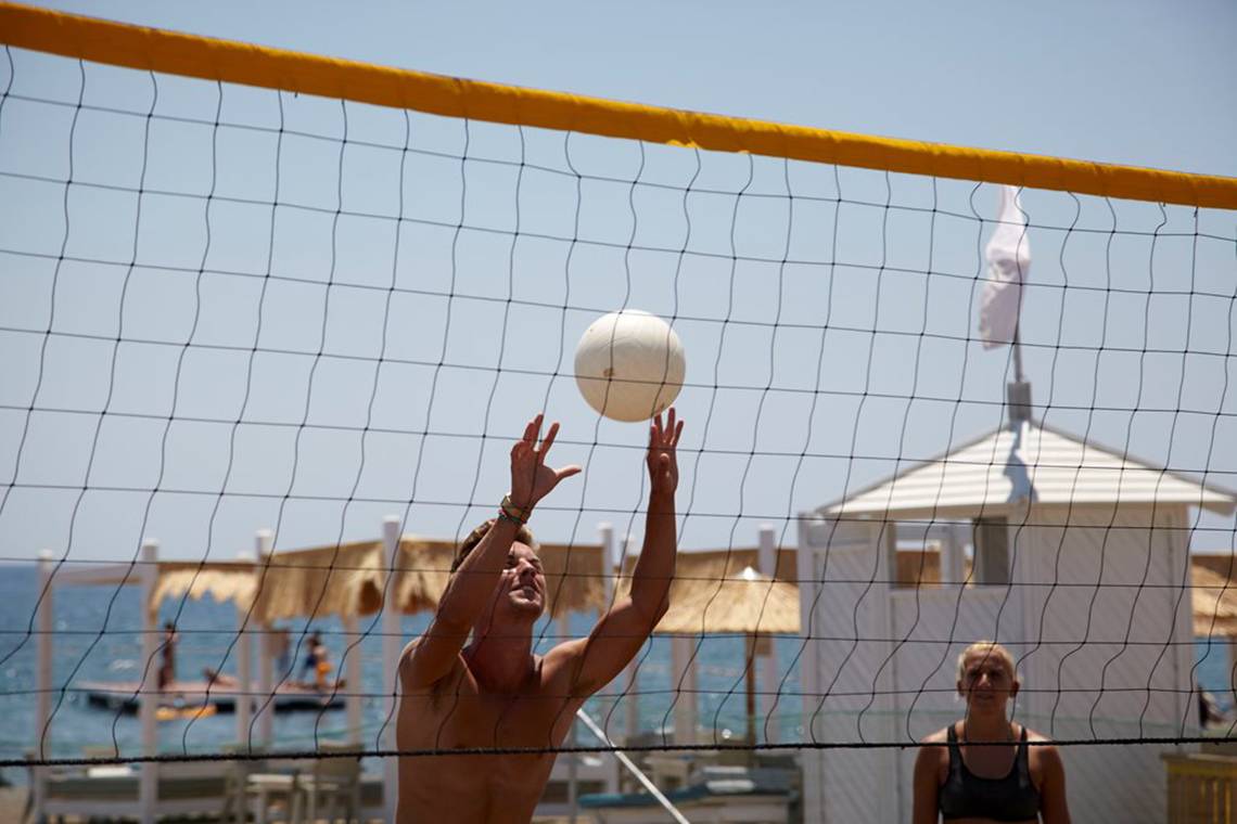 Ein Volleyballspieler im Esperides Beach Resort versucht, den Ball über das Netz zu schlagen.