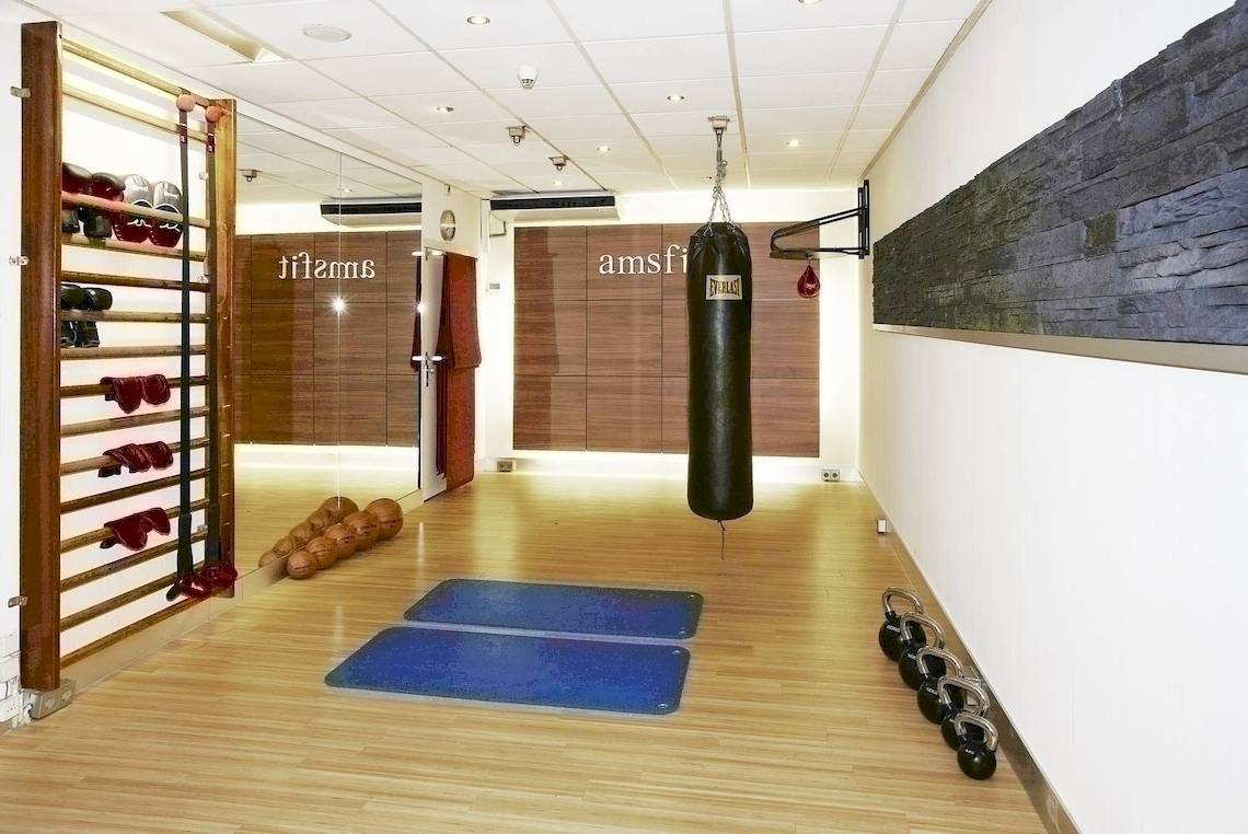 Fitnessraum im NH Amsterdam Centre Hotel mit Boxsack, Hanteln und Trainingsmatten.