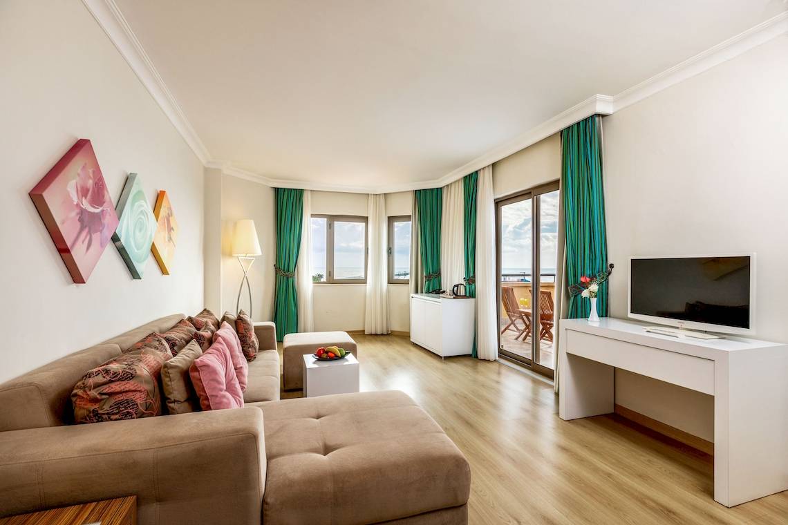 Suite im Asteria Family Resort Belek mit Wohnzimmer, Fernseher, Couch, Tisch und Fenstern