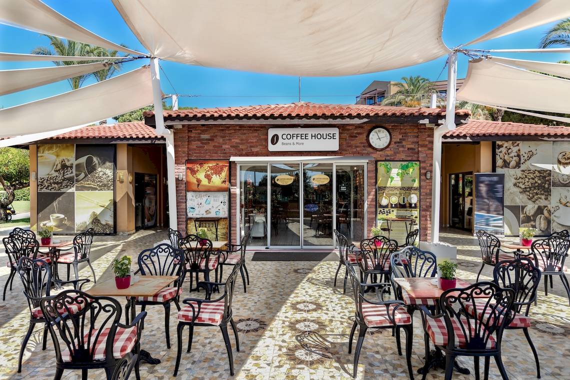 Außenbereich des Coffee House im Asteria Family Resort Belek mit Tischen und Stühlen unter einem weißen Sonnensegel.