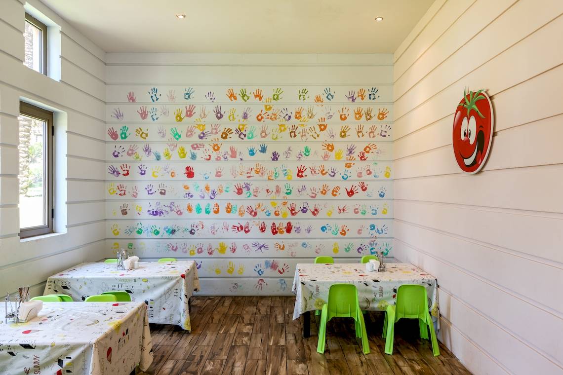 Foto eines Kinderzimmers im Asteria Family Resort Belek mit einer Wand voller bunter Handabdrücke.