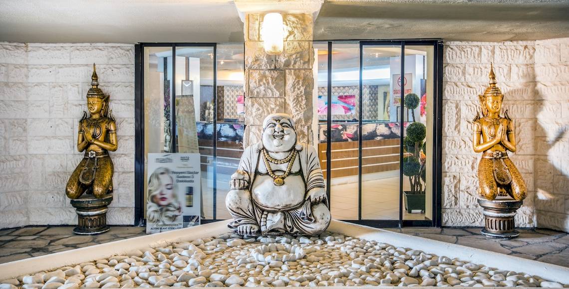 Eingangsbereich des Asteria Family Resort Belek mit goldenen Statuen und Buddha-Figur.