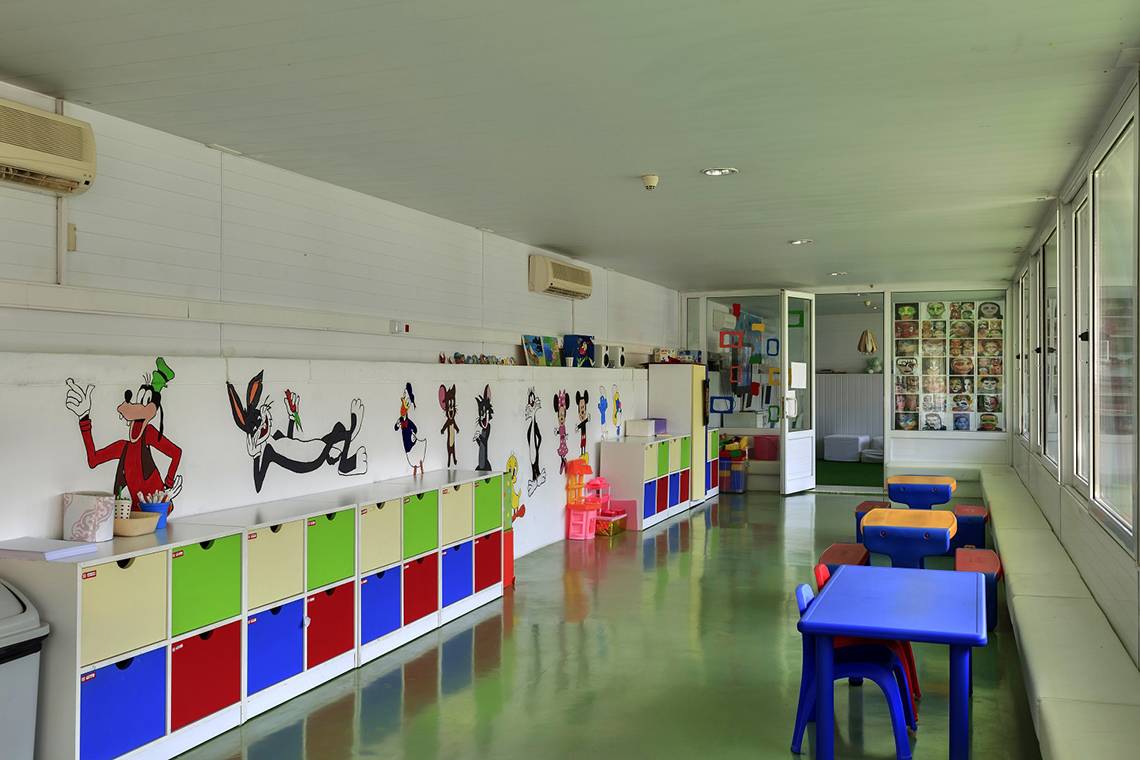 Kinderzimmer im Su Hotel mit bunten Schränken und Tischen, Disney-Zeichnungen an der Wand.