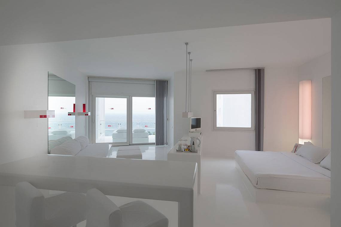 Innenraum eines Zimmers im Su Hotel mit weißem Möbeln und Ausblick auf das Meer.