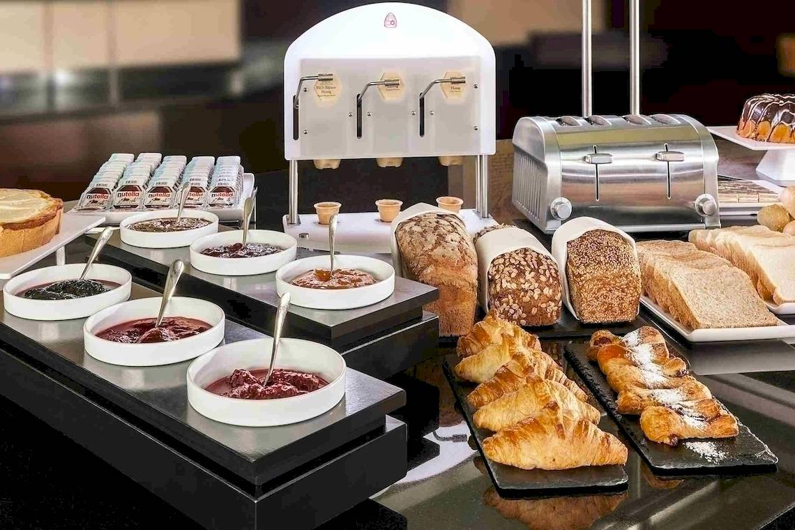 Frühstücksbuffet im NH Hamburg Altona mit Brot, Croissants, Marmeladen und Toaster.