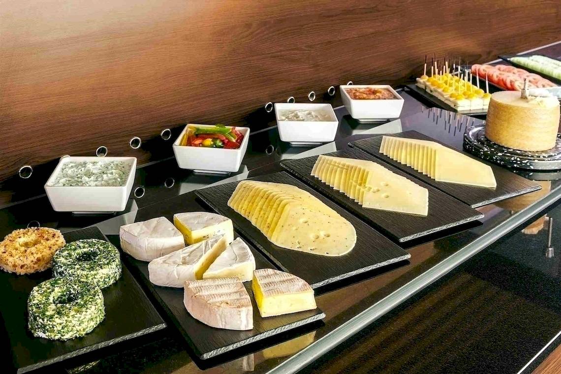 Buffet im NH Hamburg Altona mit verschiedenen Käsesorten und Gebäck.