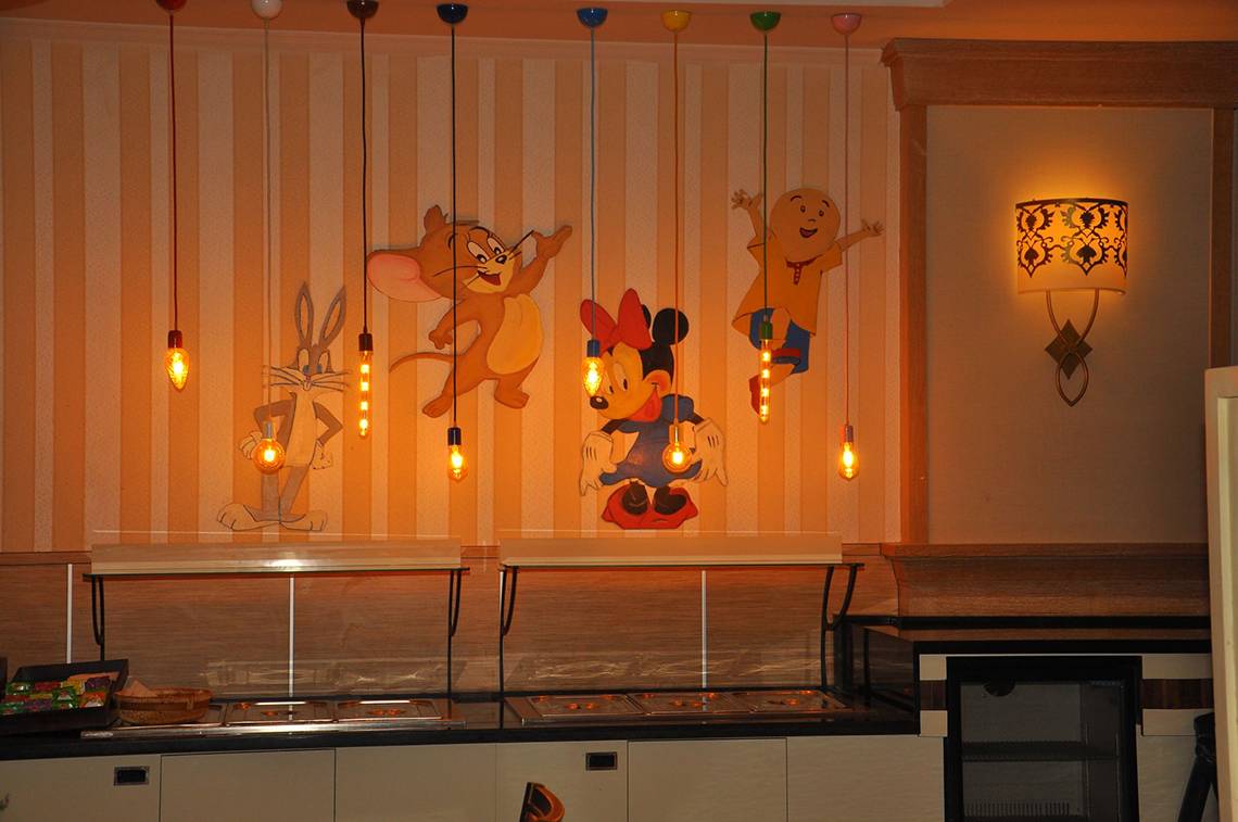 Restaurant mit Wandgemälden von Zeichentrickfiguren wie Tom und Jerry, Bugs Bunny, Minnie Mouse und Charlie Chaplin.