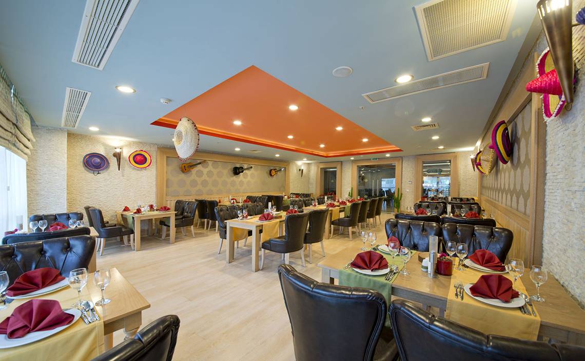 Innenbereich des Restaurants im Aydinbey Kings Palace & Spa Hotel mit gedeckten Tischen und Stühlen.
