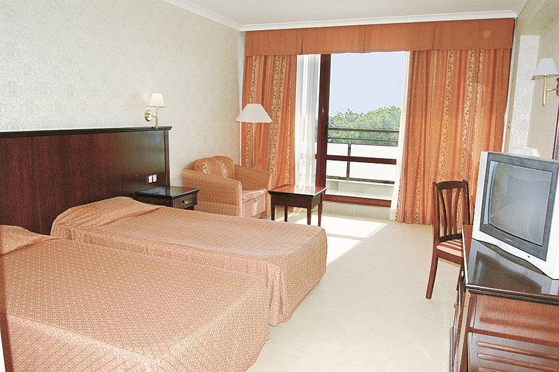 Doppelzimmer im Gladiola Star Hotel mit zwei Betten, Fernseher und einem Balkon.
