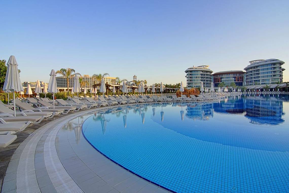 Außenpool des Baia Lara Hotels mit Sonnenliegen und weißen Sonnenschirmen.