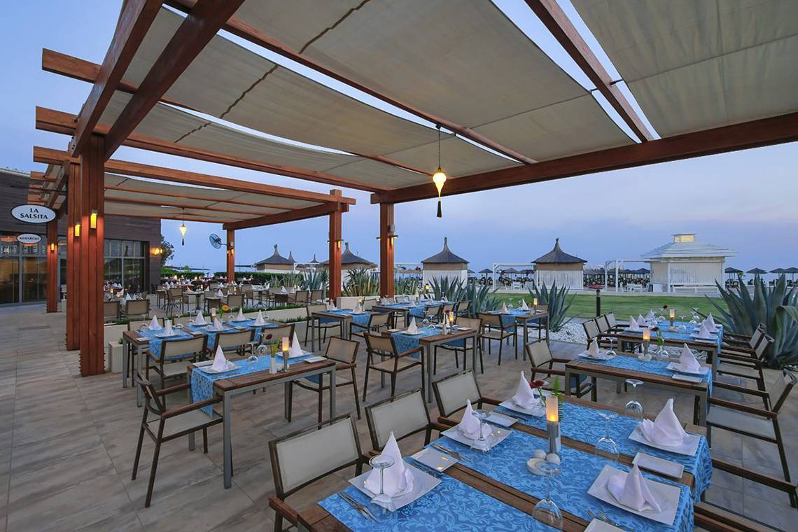Restaurantterrasse des Baia Lara Hotels mit gedeckten Tischen und Überdachungen