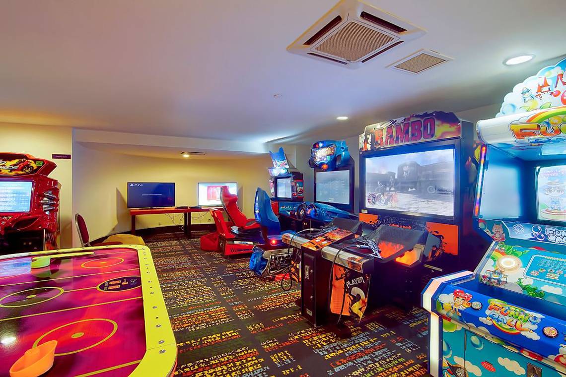 Spielzimmer im Hotel Baia Lara mit verschiedenen Arcade-Spielen und Monitoren.